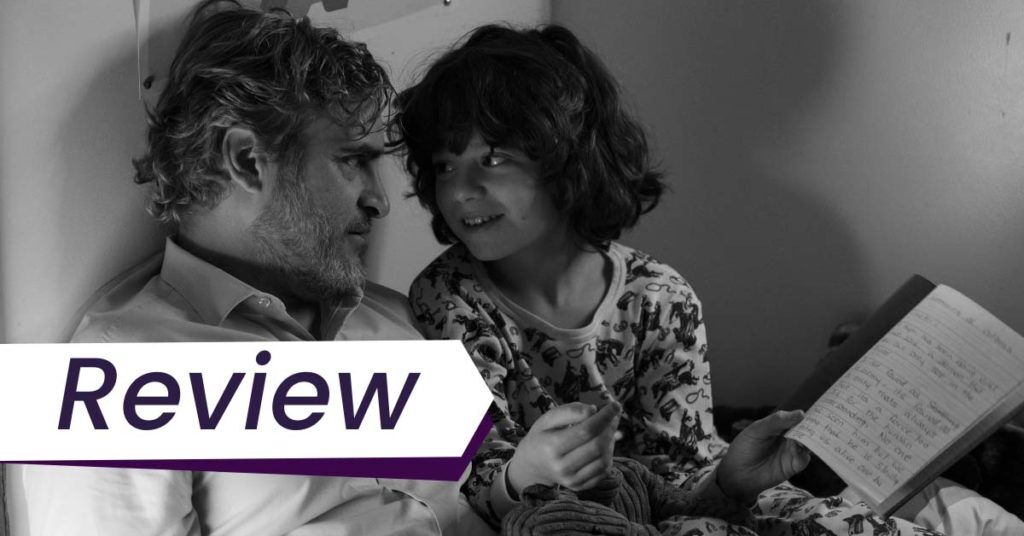 A black and white still from C'mon C'mon, in which the middle-aged Joaquin Phoenix sits down next to an excited looking young boy. The text on the images reads, 'Review'.