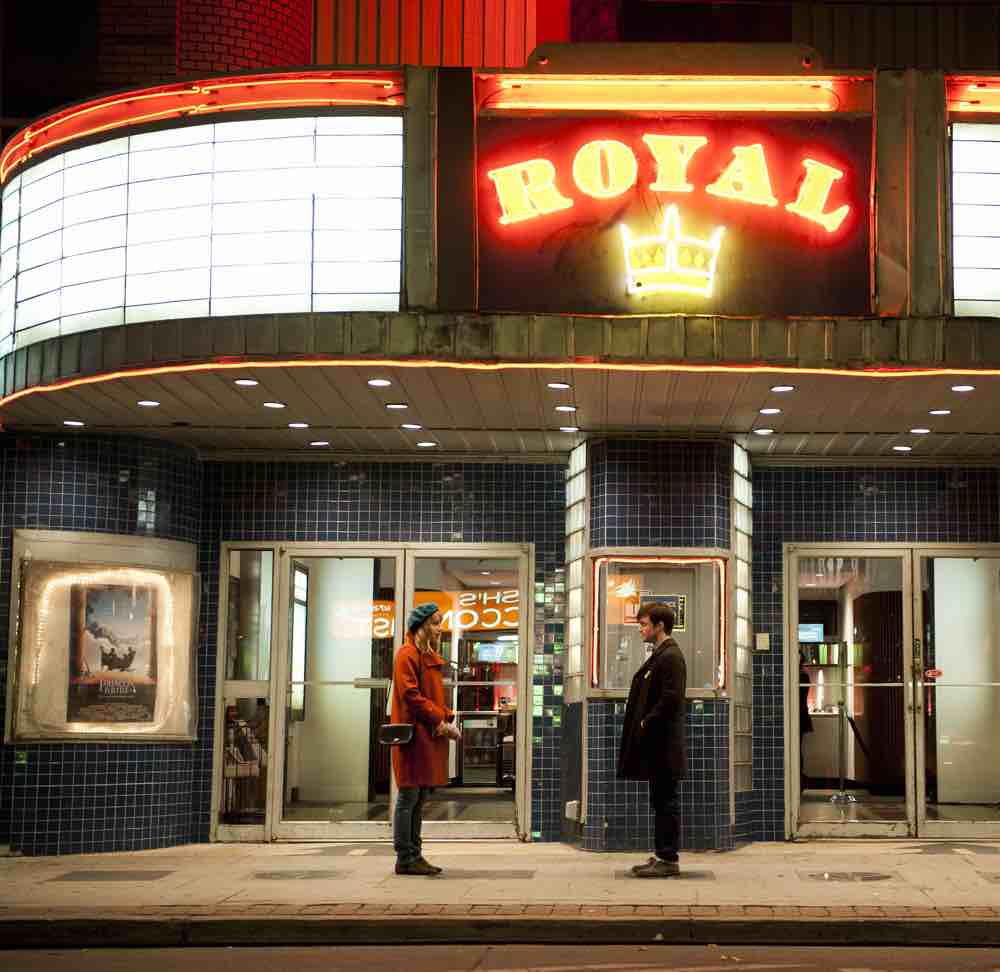 Still from the film The F Word (AKA What If). Zoe Kazan and Daniel Radcliffe stand in front of the Toronto cinema The Royal. Photo credit: Caitlin Cronenberg.