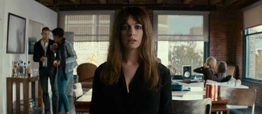 Anne Hathaway stares into the camera in a wide shote in the film.