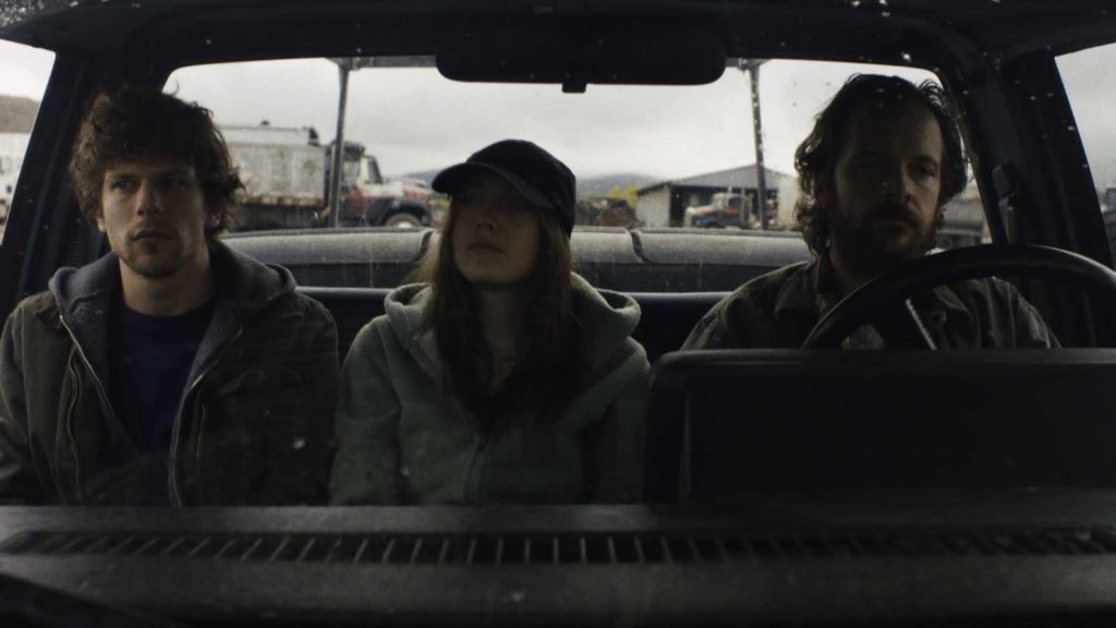 Josh (Jesse Eisenberg), Dena (Dakota Fanning), and Harmon (Peter Sarsgaard) seated on a bench seat in the front of a pickup truck in Night Moves directed by Kelly Reichardt