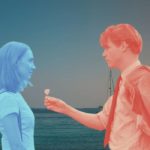 Saoirse Ronan and Billy Howle in On Chesil Beach face each other, one of them coloured in blue, the other coloured in red. They stand against a seaside background.