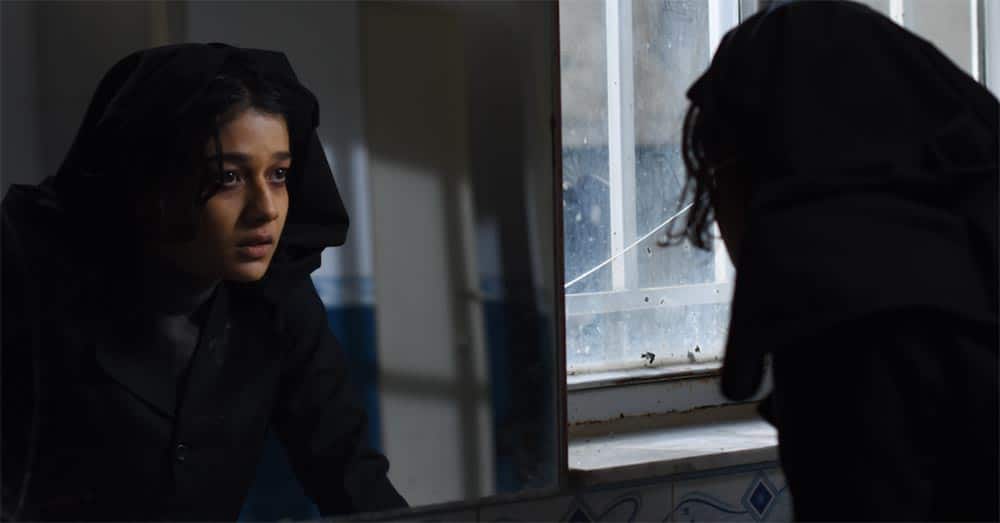 A still from the short film Exam, in which lead actress Sadaf Asghari looks at herself in a school bathroom mirror.