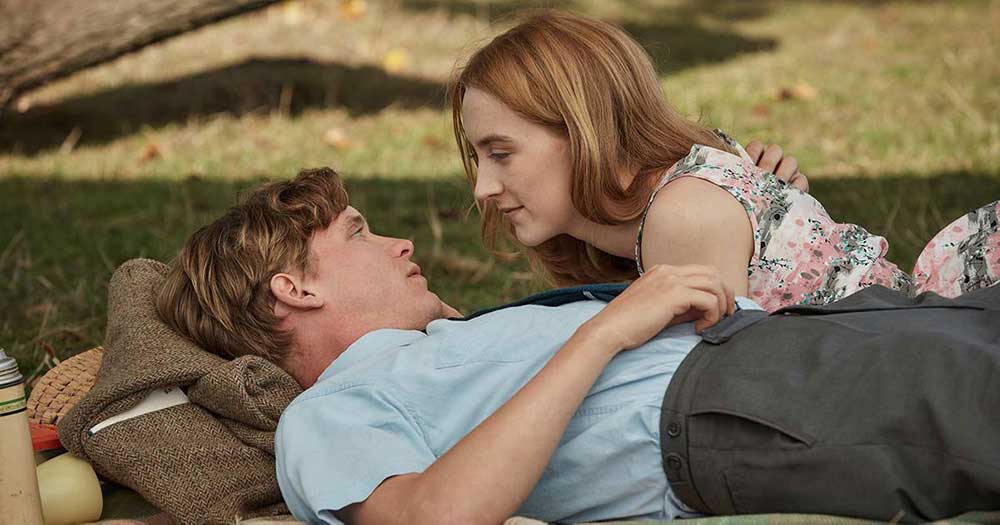 Florence and Edward lie down and gaze lovingly into each other's eyes during a flashback scene in On Chesil Beach.