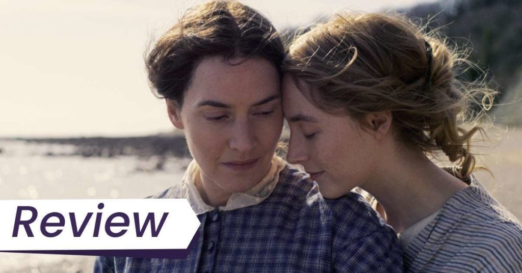 A still from Ammonite. Kate Winslet (left) and Saoirse Ronan (right) star in Francis Lee's Ammonite, which had its world premiere at TIFF. Saoirse's character, Charlotte, is resting her head on Mary's (Kate Winslet) shoulder while standing on the beach on a windy day.