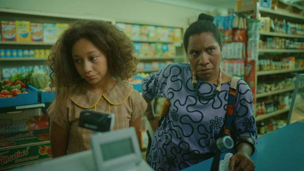 A still of a young girl and her mother at a checkout counter in Chicken, one of the best short films at LFF 2020.