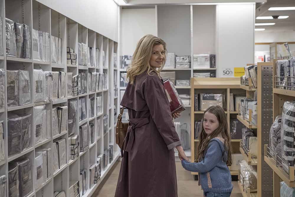 A woman and her child walk through a department store.