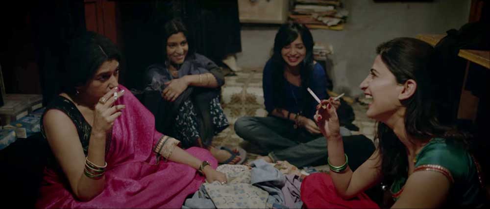 Four women sit together on the floor, laughing, in Lipstick Under My Burkha.