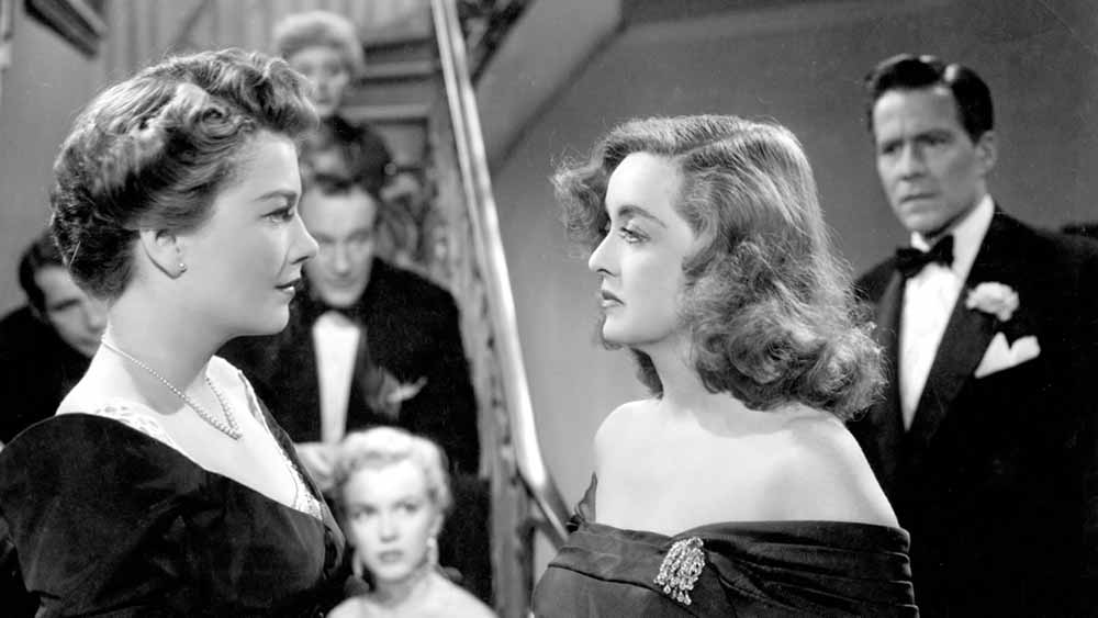 Two women face each other in a hostile manner in this black and white still from the 1950 film.