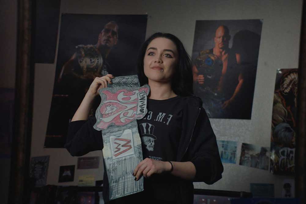 Florence Pugh as Paige, proudly clutching a cardboard replica of a WWE trophy that she made as a kid.