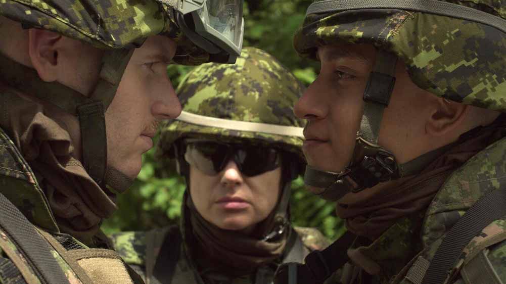 Two soldiers face off, with another soldier mediating between them.