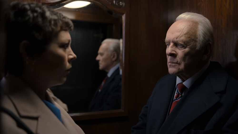 Olivia Colman and Anthony Hopkins face each other in a life, reflected in a mirror behind them, in The Father.