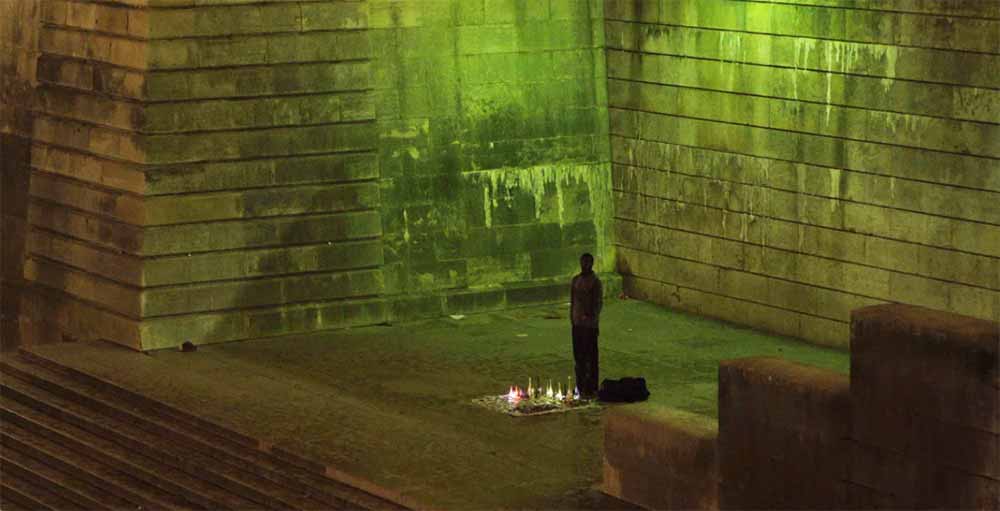 A figure stands in an urban structure, bathed in yellow light, in Dafa Meti, an LSFF 2021 title.