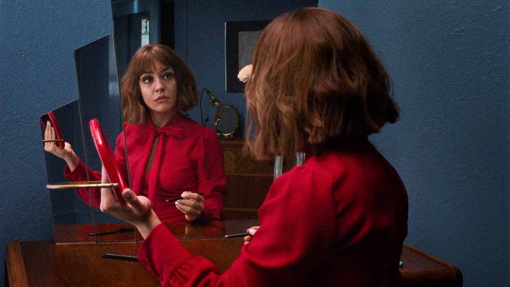 Anamari Mesa, one of the most exciting emerging actors at Sundance 2021, is dressed in red and looking into a mirror in this still from Superior.