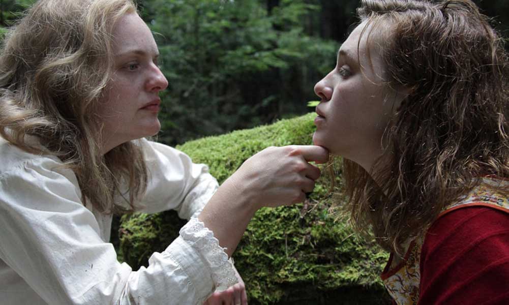 Elisabeth Moss (left) wears a white costume and Odessa Young (right) wears a white costume in the mushroom scene in Shirley.
