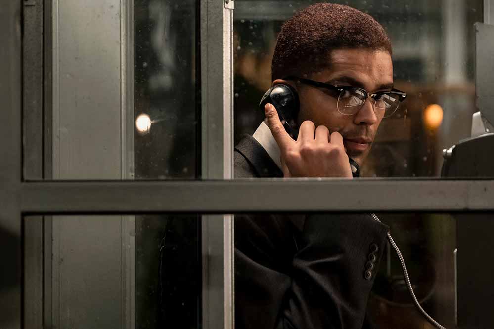 Kingsley Ben-Adir as Malcolm X in a telephone booth.