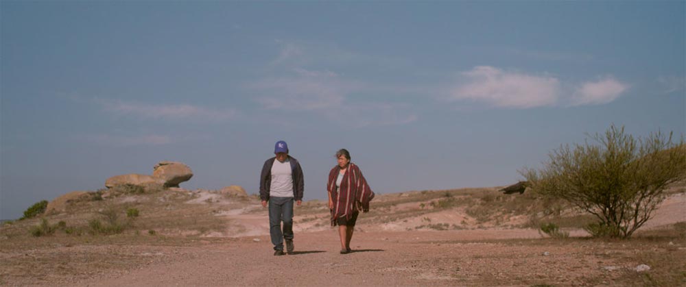 Two small figures walks through the desert in Fernanda Valadez and Astrid Rondero's Identifying Features.