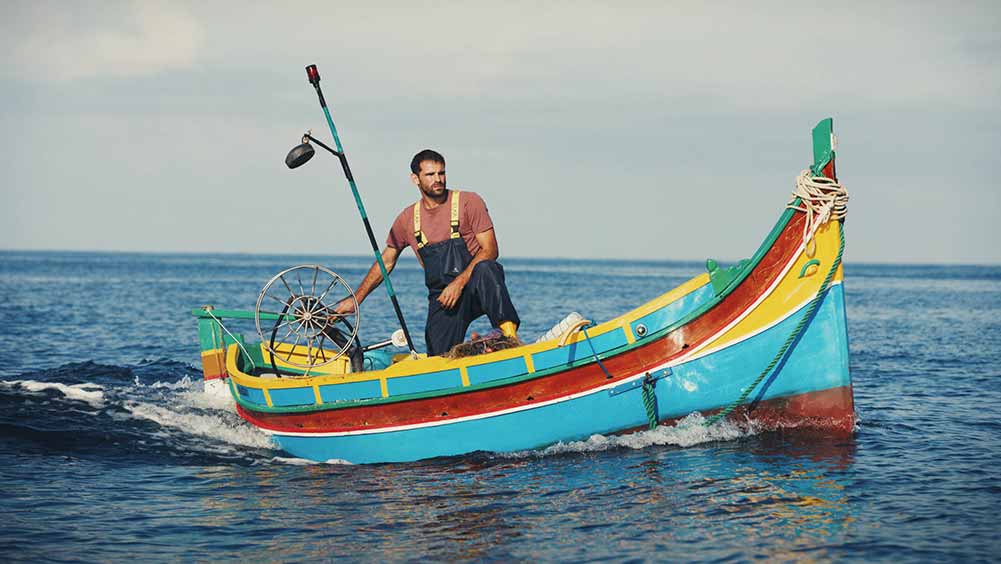 A man rides a colourful fishing boat in Luzzu, one of the best films of Sundance 2021.