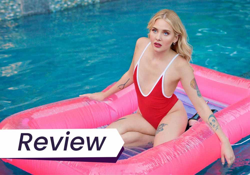A young woman in a red bathing suit sits in an inflatable raft in a pool in this still from Pleasure. The text on the image reads, 'Review'.