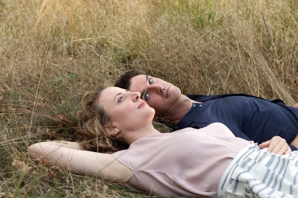 Maren Eggert and Dan Stevens are lying in a field of grass in I Am Your Man, directed by Maria Schrader, in the Competition at the 2021 Berlinale.
© Christine Fenzl