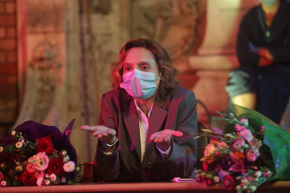 A woman in a mask holds her palms up flat in a questioning gesture in Bad Luck Banging or Loony Porn, one of the best films of Berlinale 2021.