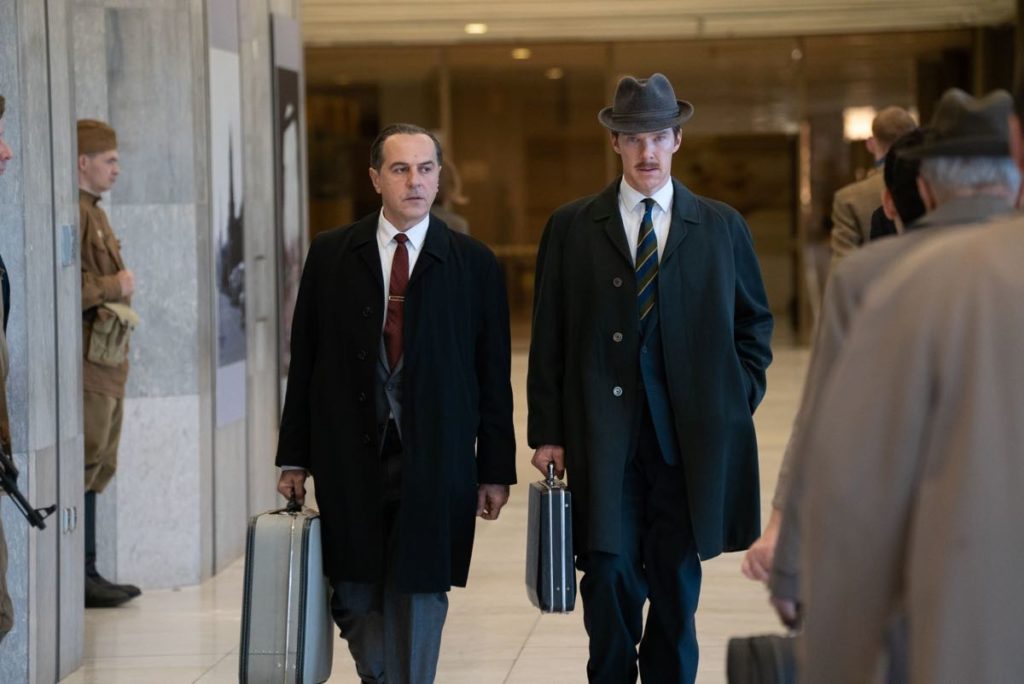 Merab Ninidze as Penkovsky and Benedict Cumberbatch as Greville Wynne in The Courier, directed by Dominic Cooke. Photo by Liam Daniel. Greville and Penkovsky are walking side by side  in the airport, each carrying a suitcase or briefcase.