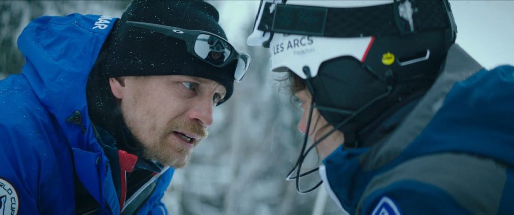 Fred (Jérémie Renier) and Lyz (Noée Abita) in Slalom, directed by Charlène Favier. Photo courtesy of Kino Lorber. The pair are facing off, in a medium shot, wearing ski gear on the slopes.