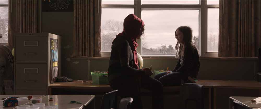 A still from Scarborough of Miss Hina sitting by the window with the young girl Laura.