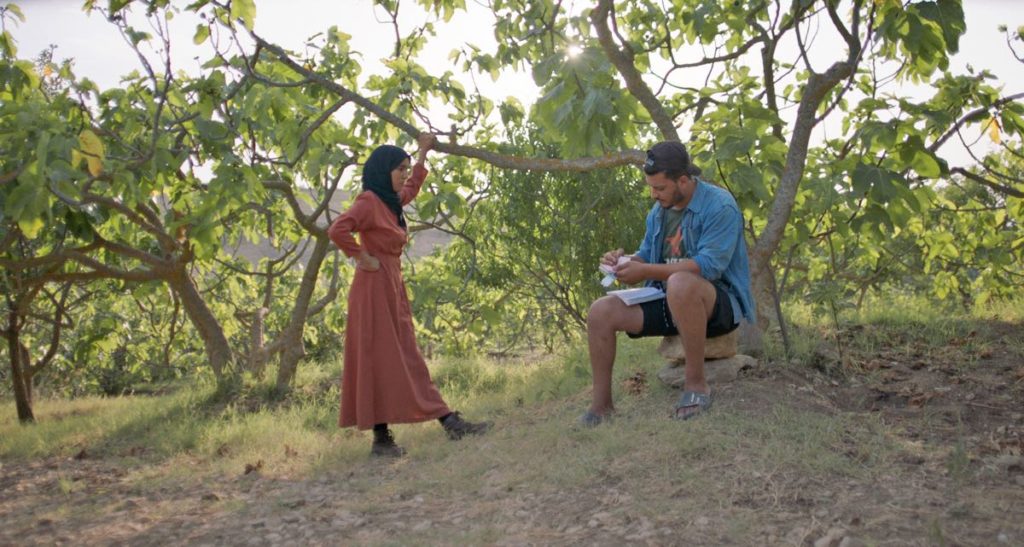 One of the workers (left) collects her pay from her boss (right) at the end of the day in Under the Fig Trees, directed by Erige Sehiri. Photo courtesy of Henia Production and Maneki Films.