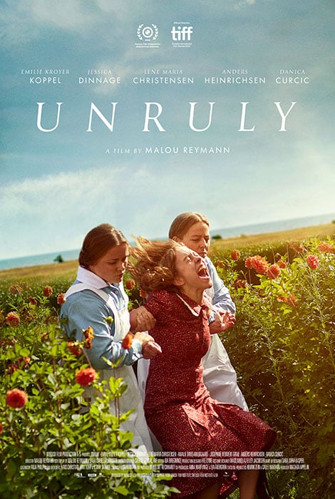The poster for Malou Reymann's feature film Unruly which Alex Heeney reviews from its world premiere at TIFF. A young woman in a red dress screams as she's restrained by two women dressed like nurses, in blue with white pinafores, in a field.