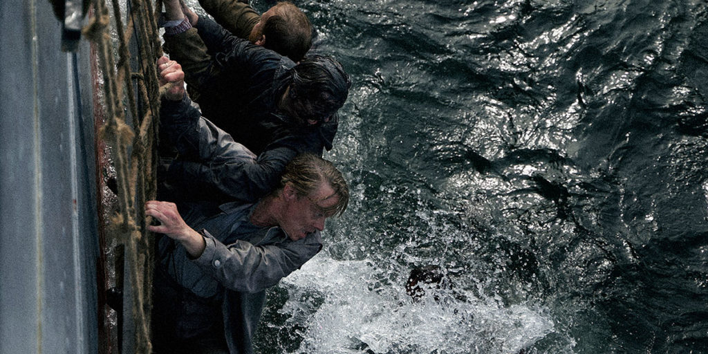 Still from the film War Sailor, directed by Gunnar Vikane, which Alex Heeney reviews out of TIFF. Photo courtesy of TIFF. Alfred and his colleagues hang off of a sinking ship. Three men cling to the ropes on the side of a sinking ship, while looking down at the choppy ocean below.