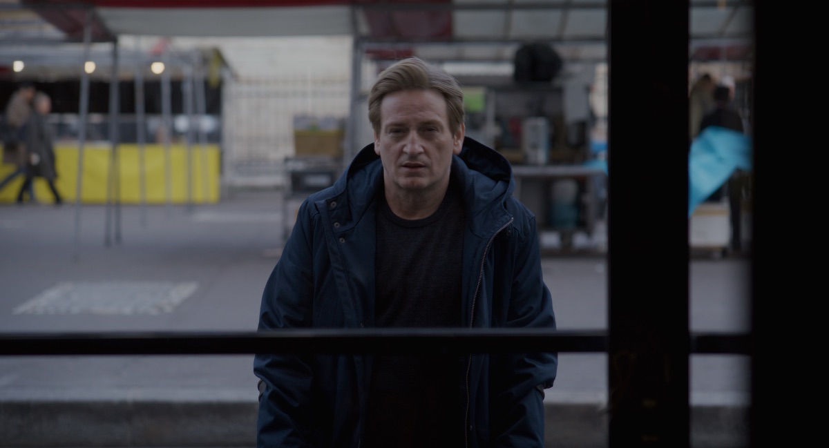 Thomas (Benoît Magimel) looks into the window of the restaurant where the attack was from outside in daylight in Alice Wincour's film Revoir Paris. Alex Heeney interviews Alice Winocour about the film. 