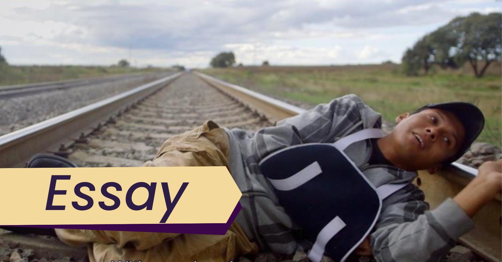 Still from the film Border South, which Dr. Kevin Anzzolin views through the lens of the philsophy of migration in this essay. A man with his arm in a sling lies down on the railroad tracks in Border South